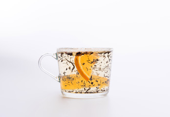 Transparent cup of tea with slice of orange isolated on white background
