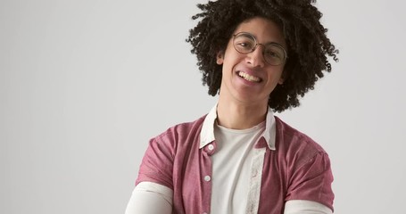 Young egyptian man with curly hair smiling over white background