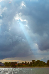Sun rays shining through dark cloudy sky