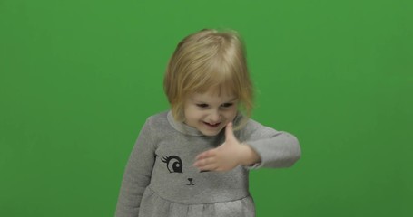 Kid girl on a Green Screen, Chroma Key. Happy three years old girl