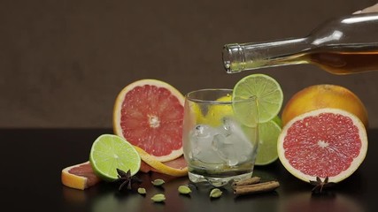 Pour whiskey, cognac, liqueur from a bottle into a glass cup