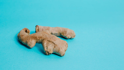 Ginger root on a blue background. Isolated ginger whole. Help in treatment. The concept of using...