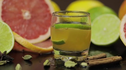 Lime slice falls into a glass cup with an alcoholic cocktail