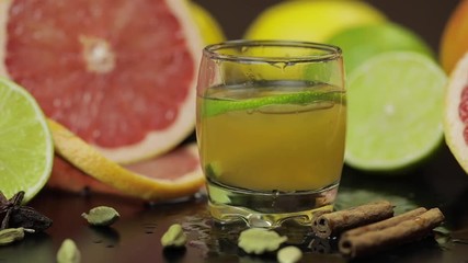 Lime slice falls into a glass cup with an alcoholic cocktail