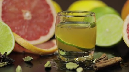 Lime slice falls into a glass cup with an alcoholic cocktail