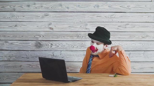 Office worker clown, clown concept at work. Businessman at the computer, work on a laptop.