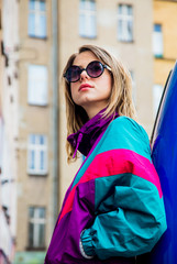 woman in jacket of 90s style stay at counrtyard of house