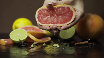 Woman squeezing a fresh and juicy grapefruit with hands. Fresh fruits