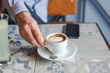 Unrecognizable person holding a cup of coffee at cafe