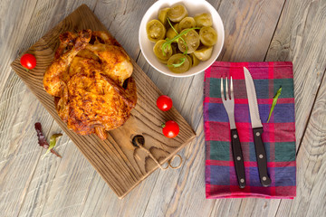 Grilled chicken and marinated tomatoes on wooden background