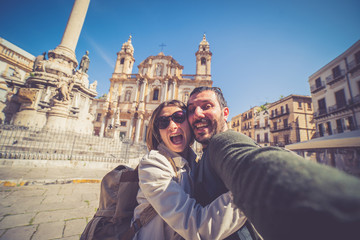 happy tourist couple taking selfie in Palermo in the San Domenico church in Palermo square, Sicily,...