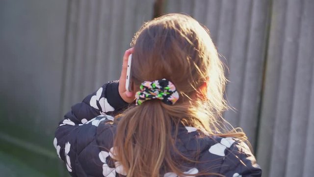 A girl is talking on the phone and accidentally drops the phone close-up
