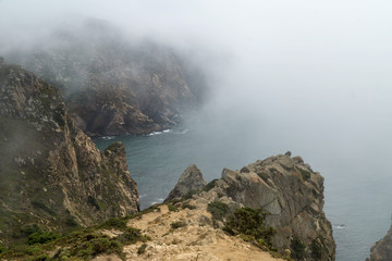 Cape Roca (Cabo da Roca) cliffs in fog. The rocks are obscured by clouds or fog. Cape Roca is most western part of Europe, Portugal.