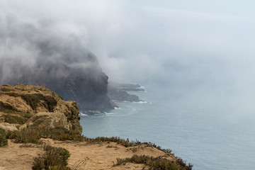 Cape Roca (Cabo da Roca) cliffs in fog. The rocks are obscured by clouds or fog. Cape Roca is most western part of Europe, Portugal.