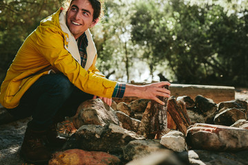 Obraz premium Man camping in the countryside making a bonfire