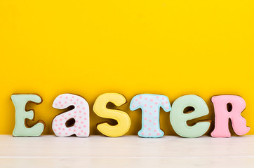 Bright Easter background.  Decoration eggs and colorful letters forming words  EASTER. Celebration concept.