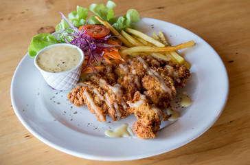 Chicken fried steak with country gravy and french fries. Pork chop, French fries and vegetables. Homemade Country Fried Steak with Gravy and Potatoes 