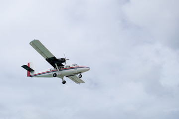 Fototapeta na wymiar White twin otter DHC-6 aircraft with wheels down, preparing for landing