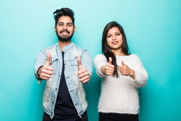 Young indian couple, man and woman with thumbs up isolated on blue background