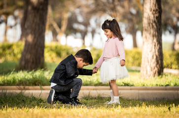 Kneeling boy Proposing - Boy proposing marriage with a romantic gesture his girlfriend