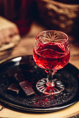 Glass of red liquor with chocolate bars