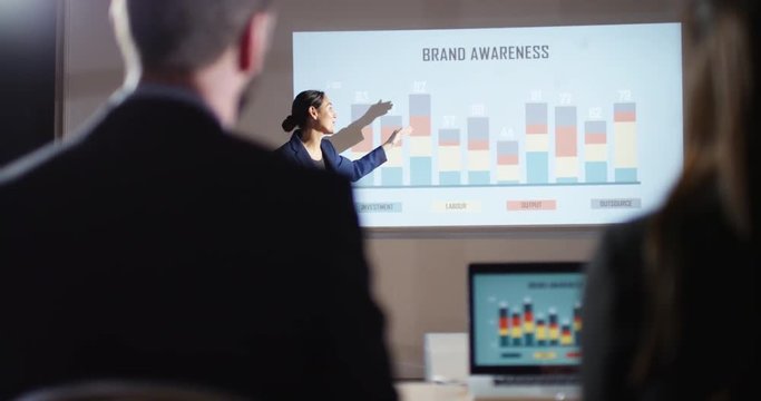 4K Marketing businesswoman giving presentation showing animated graphs on screen
