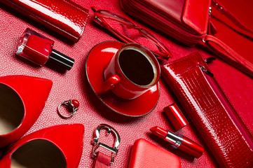 Woman red accessories with coffee, cosmetic, jewelry, gadget and other luxury objects on leather background, fashion industry, modern female concept, selective focus