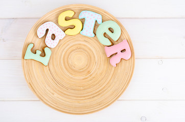 Homemade Easter pastry in shape of letters and eggs on wooden background.