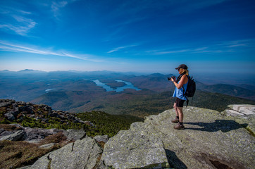 Obraz premium female hiker enjoying the view from the summit of Whiteface Mountain
