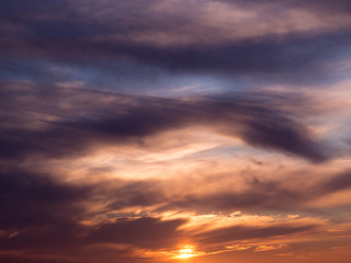 Dark dramatic clouds in sky at sunset with blue orange gradient