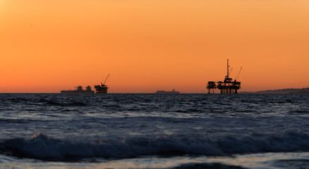 Obraz premium Offshore oil drilling rigs at sunset
