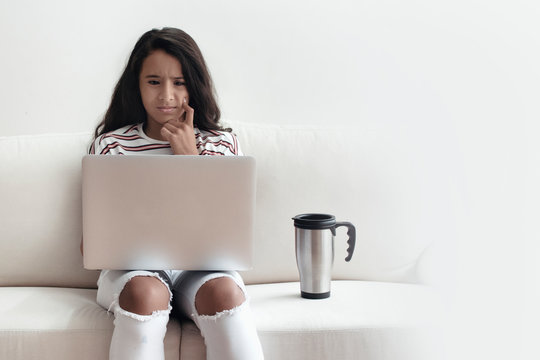ni&ntilde;a joven utiliza computadora port&aacute;til sorprendida