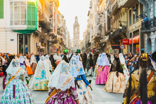 Fototapeta Several of the thousands of women Falleras who parade down the street of La Paz with their typical Valencian Spanish dresses during the offering of Fallas to the Virgin, seen from behind.