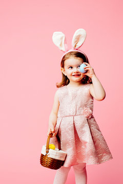 Portrait of a little toddler girl with bunny ears and easter egg