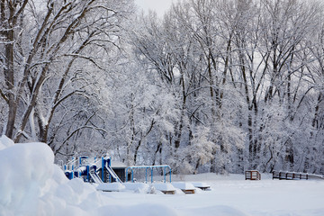 Children's playground covered in a winter wonderland of fluffy white snow