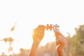 hands holding piece of red jigsaw puzzle. teamwork concept