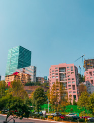Fototapeta premium Full shot view of a part of Mexico city located in Santa Fé. includes corporate buildings and apartments surrounded by trees on blue sky