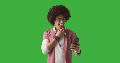 Stylish man text messaging on mobile phone over green chroma key background