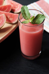 Glass of guava smoothie and slice of its fruit