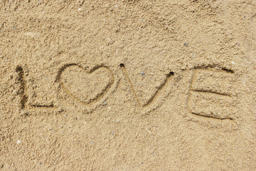 Love word written on the sand at the beach, natural background of love symbol