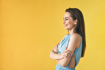 Beautiful smiling woman profile portrait on yellow background with copy space