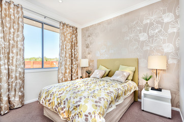 Modern bedroom with a master bed and light brown color curtain decorations of a luxury house