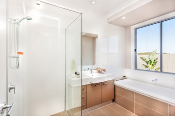 Fototapeta na wymiar Modern bathroom with a faucet, water tub and a dark brown floor tiles