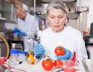 Female geneticist conducting experiments with fruits and vegetables