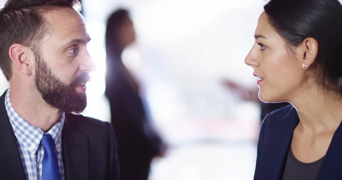4K Close up on faces of business man & woman having an in-depth discussion