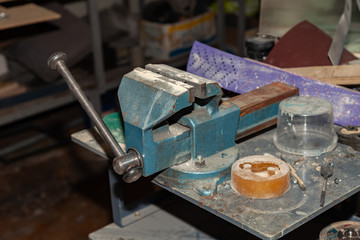 Old vice of blue color for a strong clamping of objects and further industrial work in a workshop for production. Tool for Manufacturing