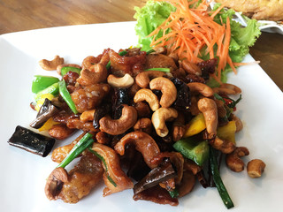 Stir fried Chicken with cashew nuts on the white dish for clean food of concept