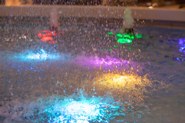 Close-up on a fountain with colored lights in the form of a dome spraying water in different directions