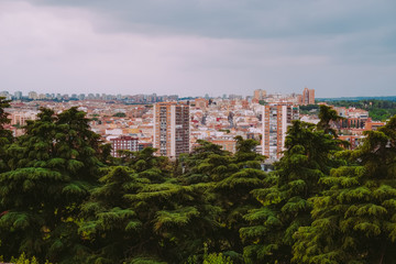 Fototapeta na wymiar Aerial view of buildings in the city with green trees in Madrid, Spain.