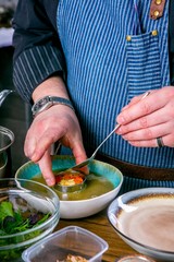 Chef decorates the soup Fo Bo from smoked catfish with cellophane noodles. Master class in the kitchen. The process of cooking. Step by step. Tutorial. Close-up
